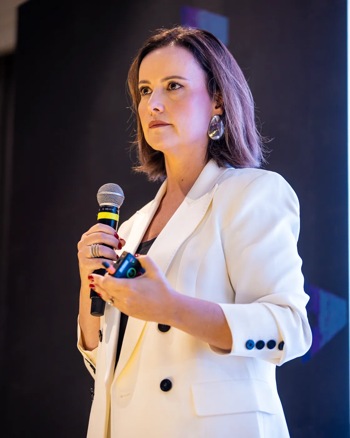 Maria Taunay de microfone na mão, conduzindo um treinamento de equipe